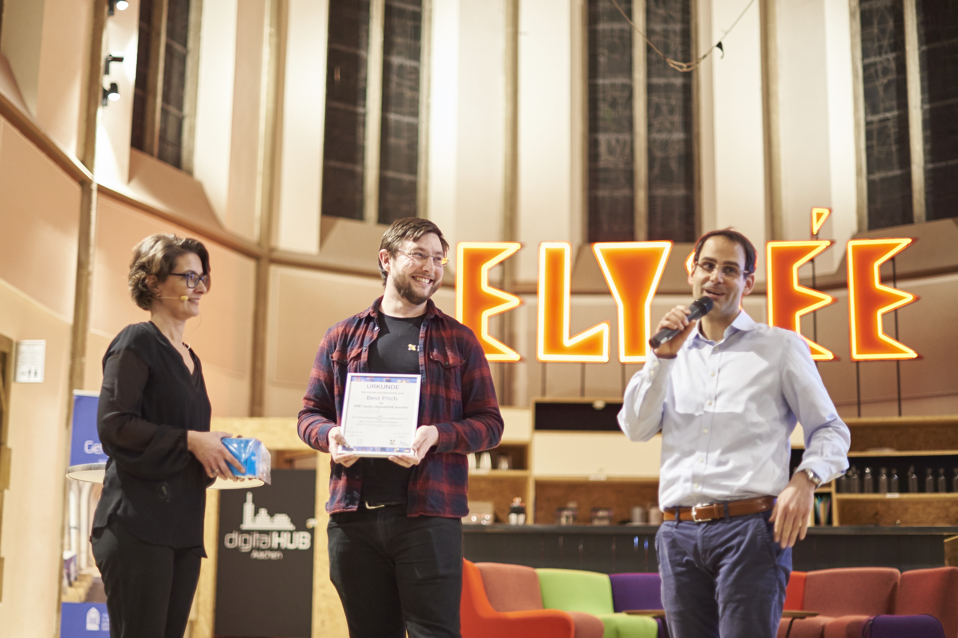 Jasper Heuser, freut sich über die Auszeichnung für den besten „Pitch“, überreicht von Stefanie Pick (digitalHUB Aachen e. V.) und Goar T. Werner (Geschäftsführer AACHEN BUILDING EXPERTS e. V.). Foto: Sabine Schmidt, das-design-plus.de